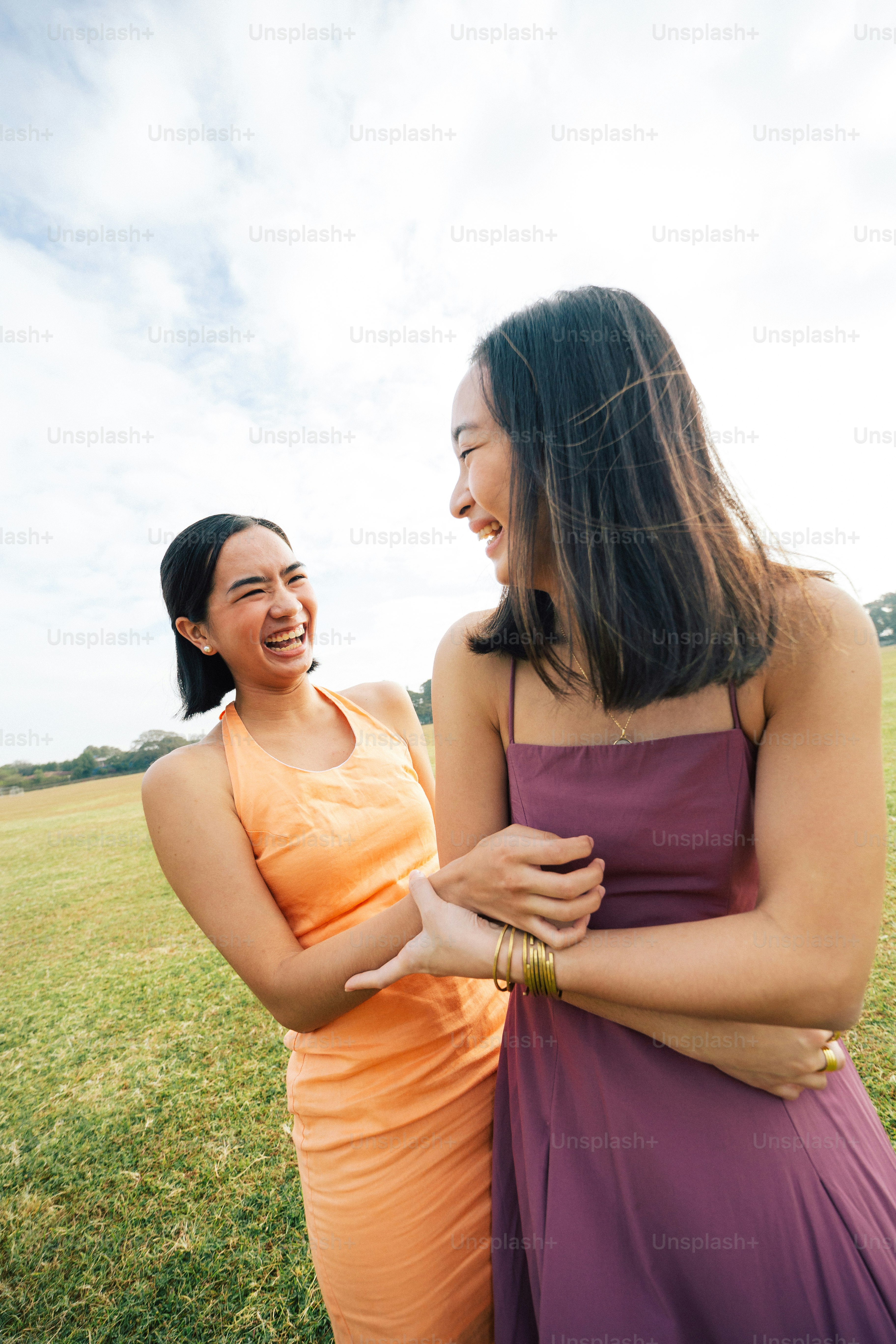 a couple of women standing next to each other in a field