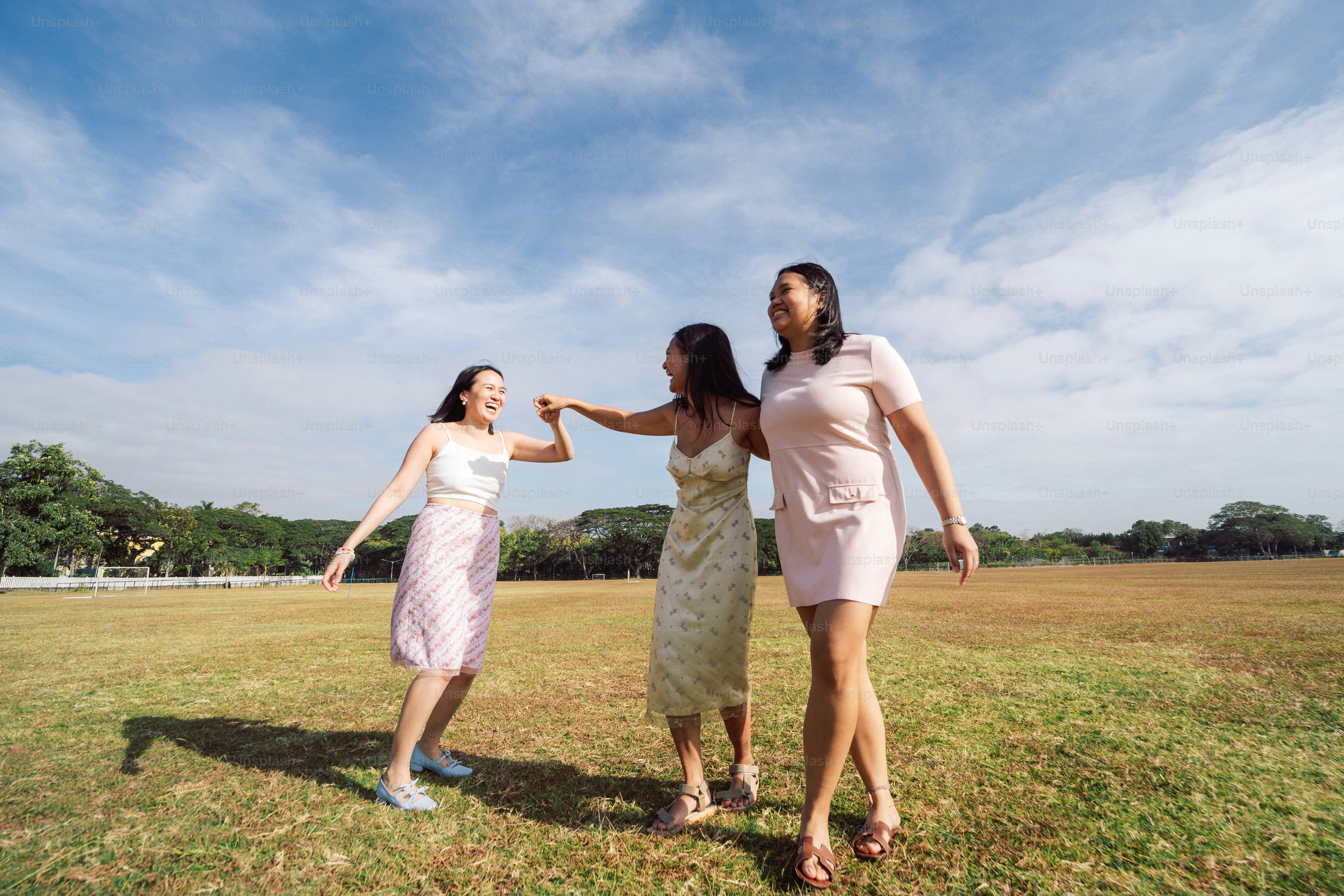 a group of women standing on top of a lush green field