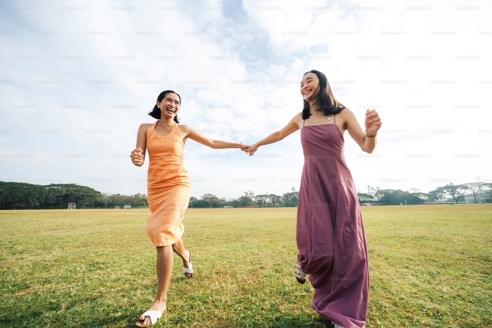 a couple of women walking across a lush green field