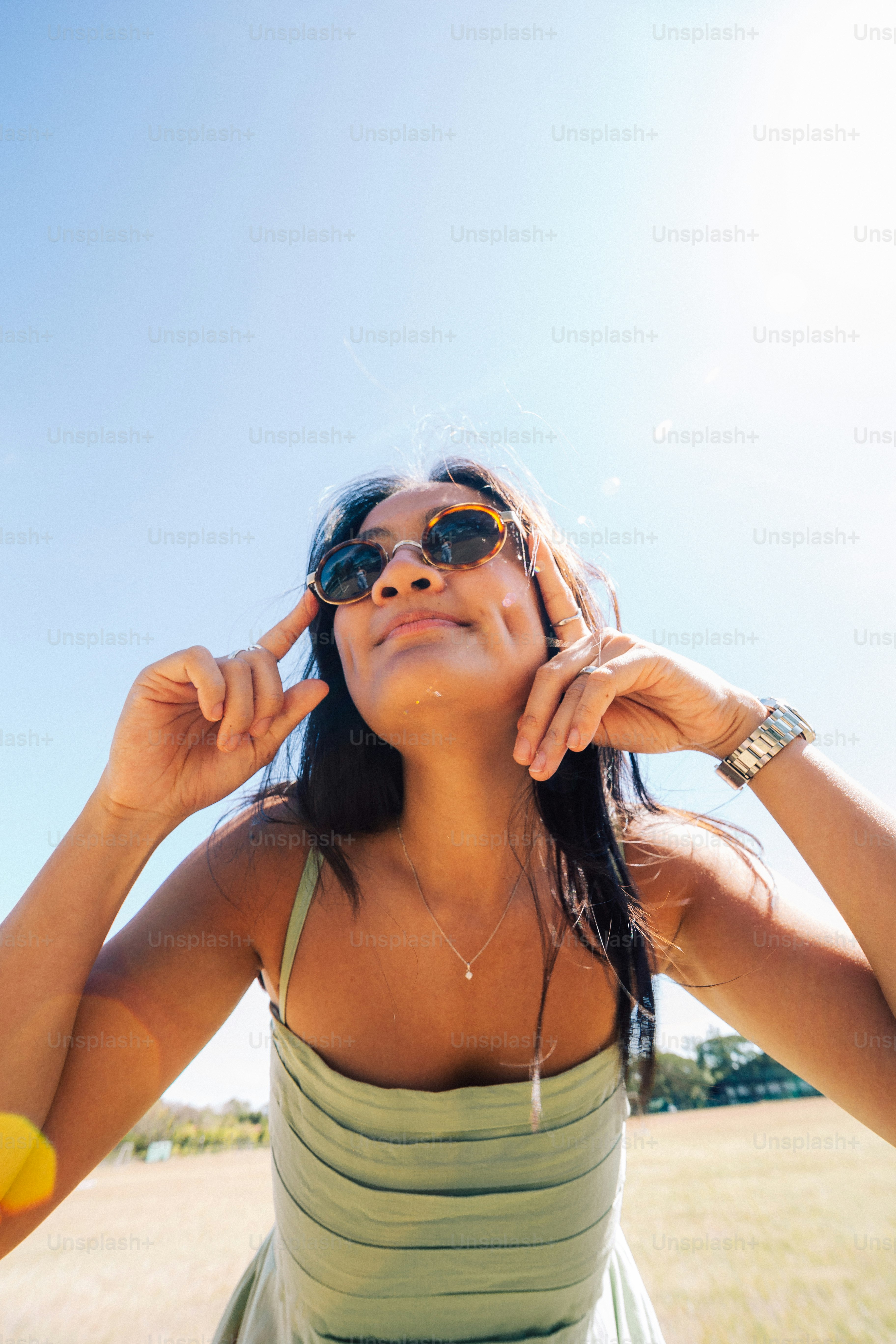 Eine Frau in einem grünen Kleid hält sich die Hände an die Ohren