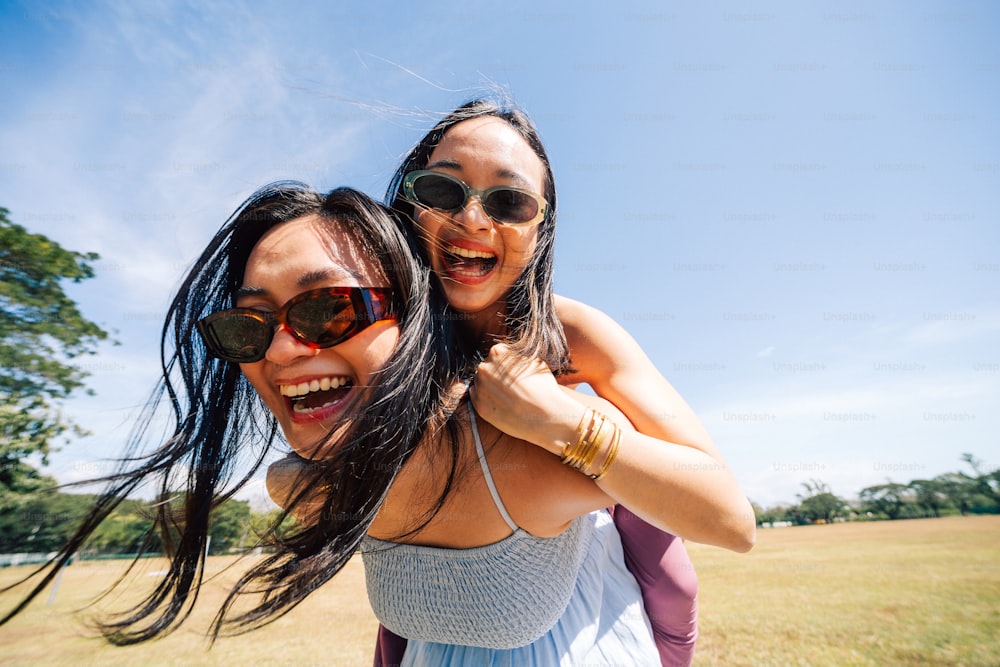 a couple of women standing next to each other in a field