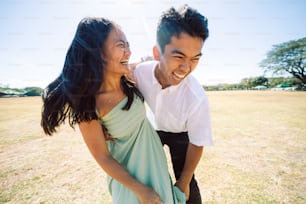 a man and a woman laughing in a field