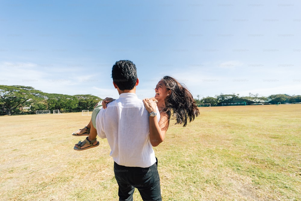 um homem carregando uma mulher nas costas em um campo
