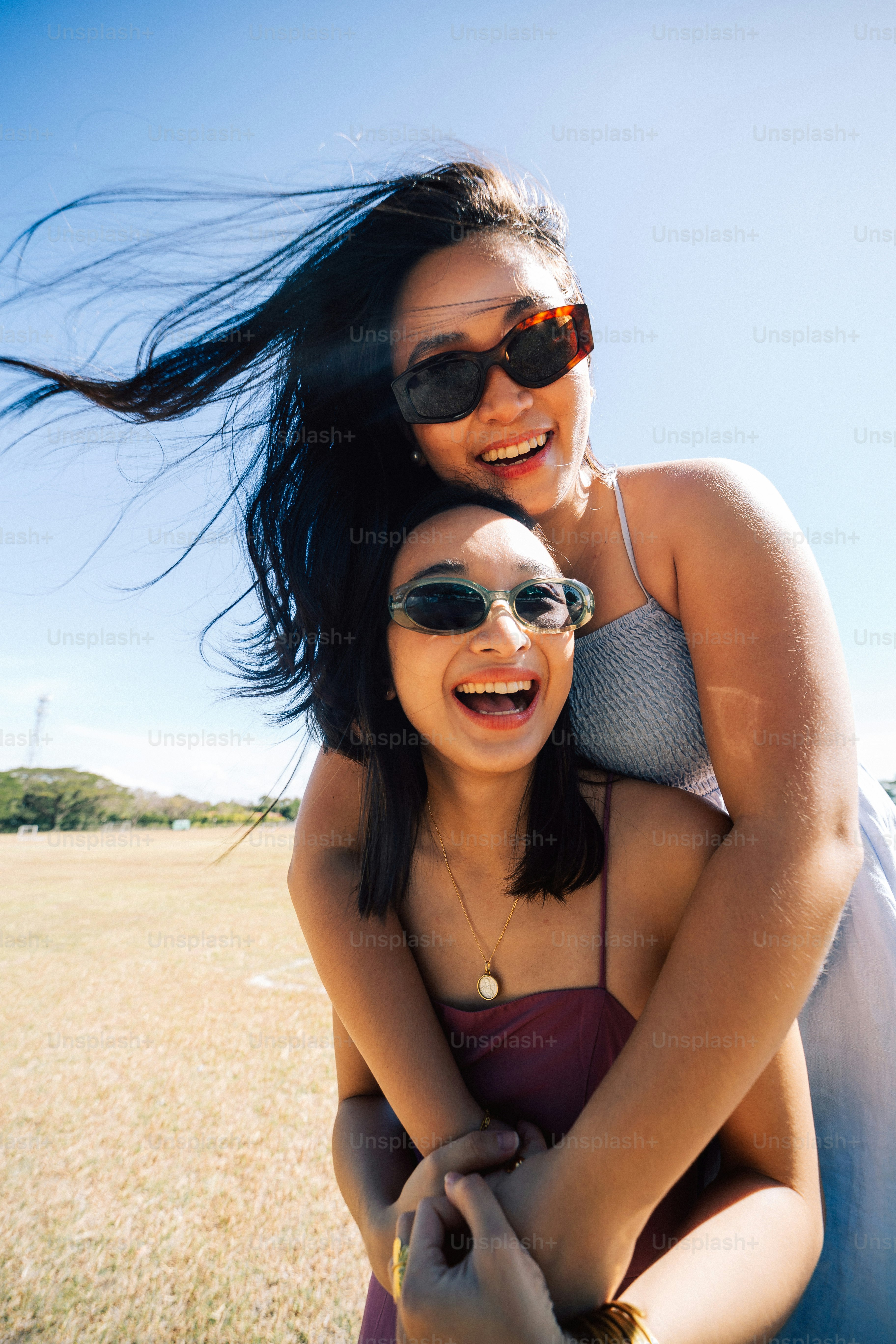 a woman holding a girl on her back in a field