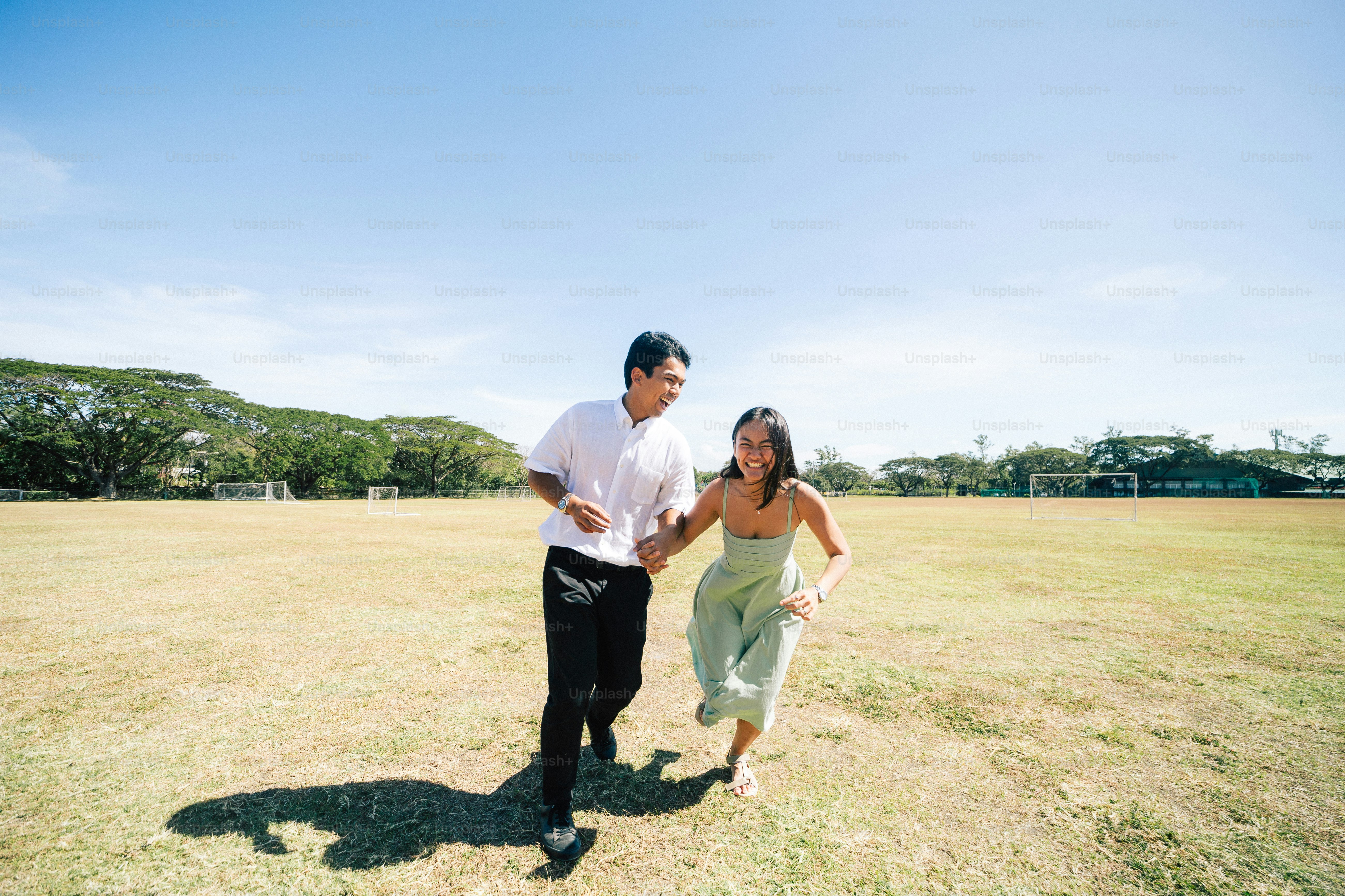 a man and a woman running in a field