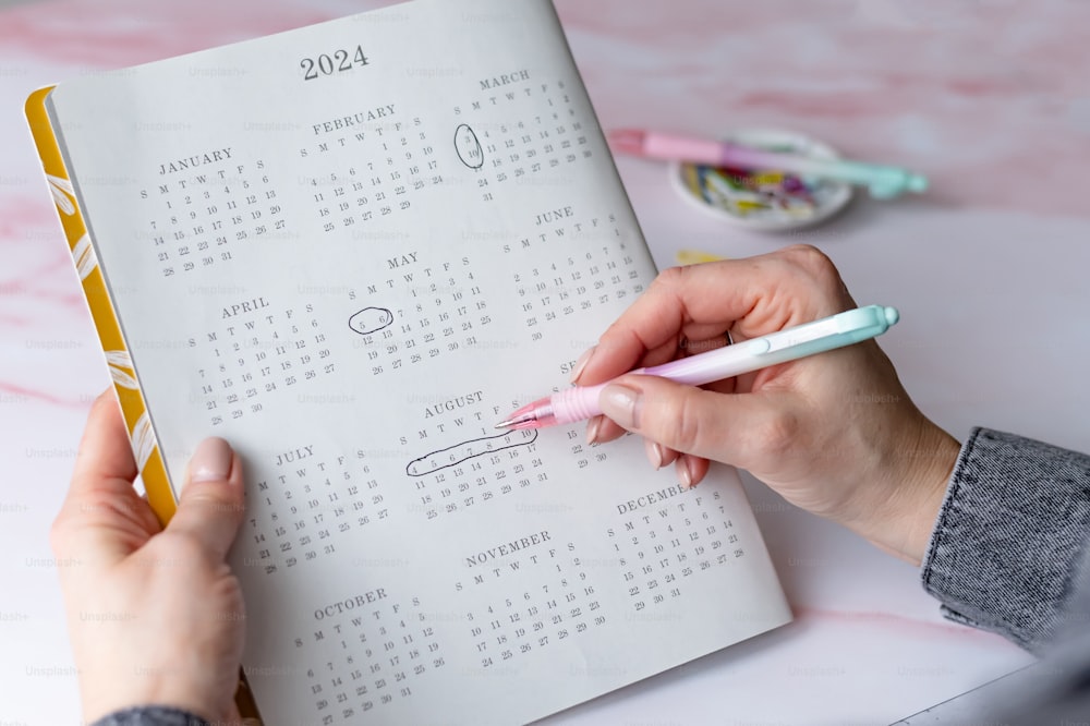 Una persona está escribiendo en un libro de calendario