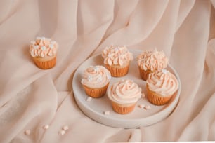 a plate of cupcakes with frosting on top