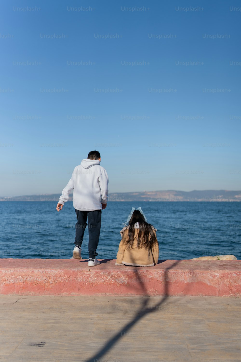 a man standing on the edge of a pier next to a body of water