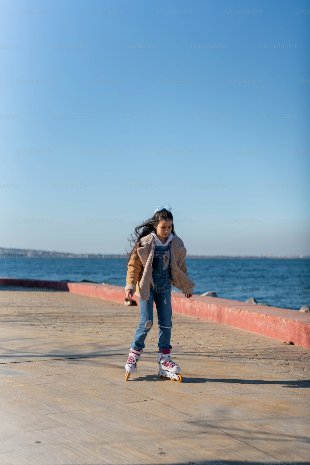 a young girl riding a skateboard on a beach