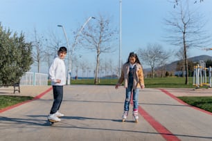 스케이트보드를 타고 보도를 따라 내려가는 두 명의 아이들