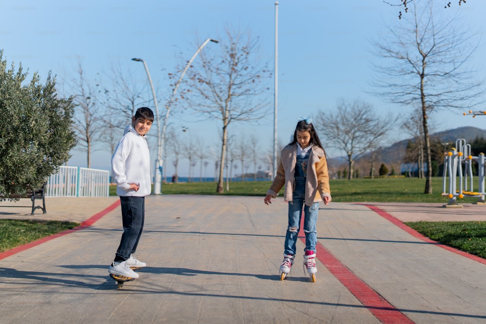 a couple of kids riding skateboards down a sidewalk