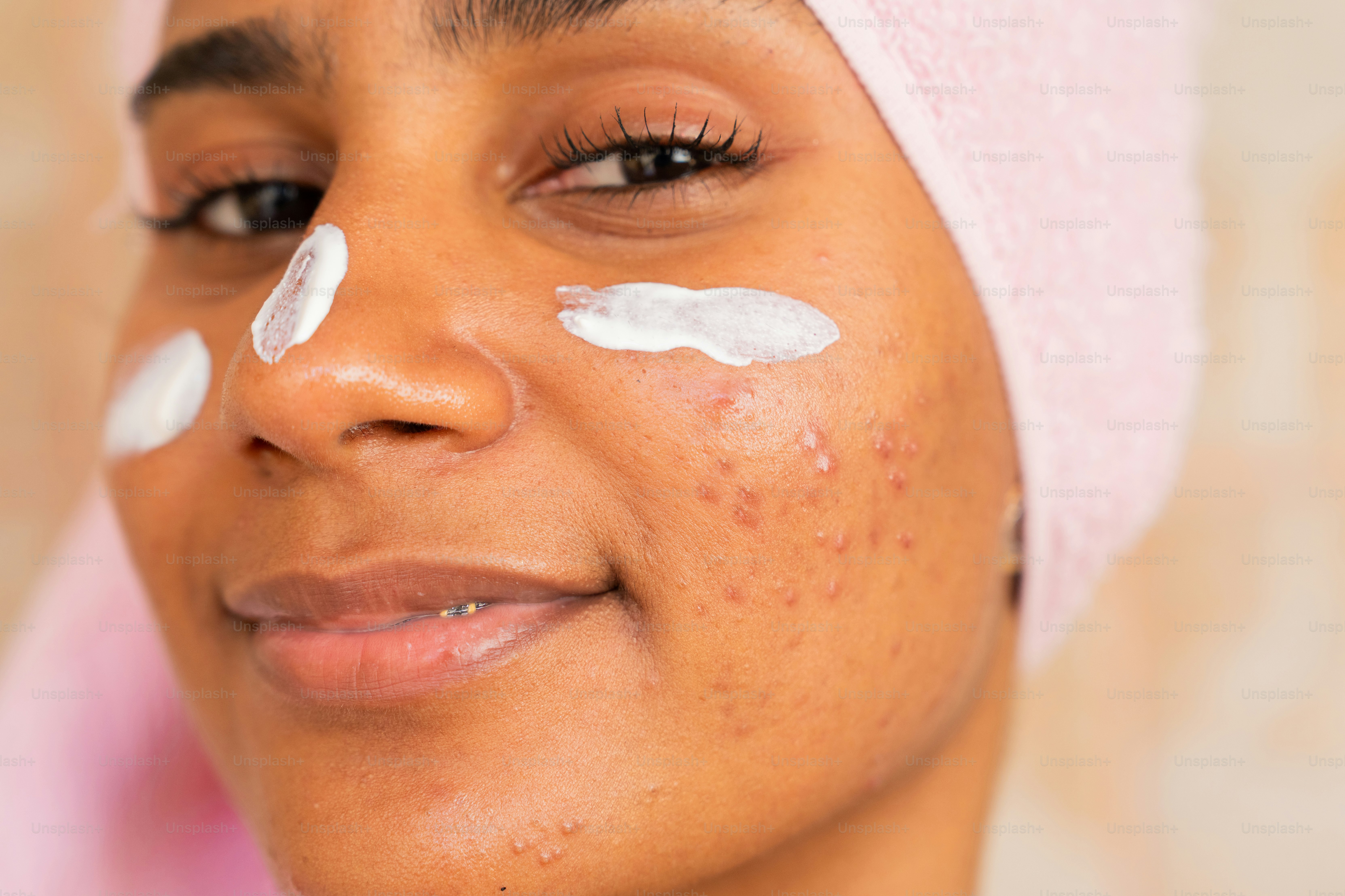 a woman with a towel on her head with a lot of cream on her face