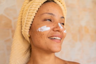 a woman with a towel on her head has a cream on her face