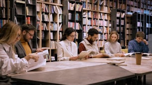 a group of people sitting at a table in a library