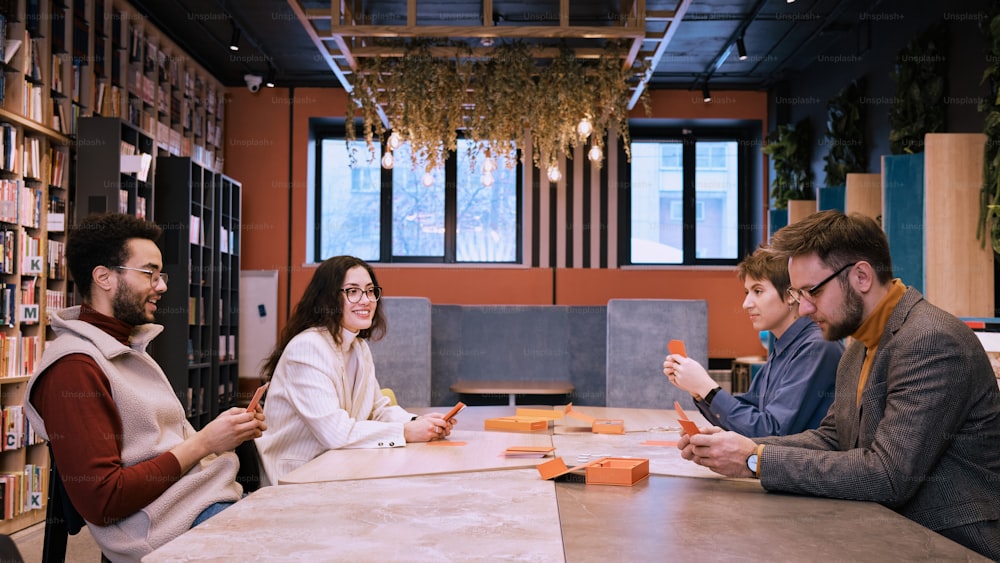 a group of people sitting around a table in a library