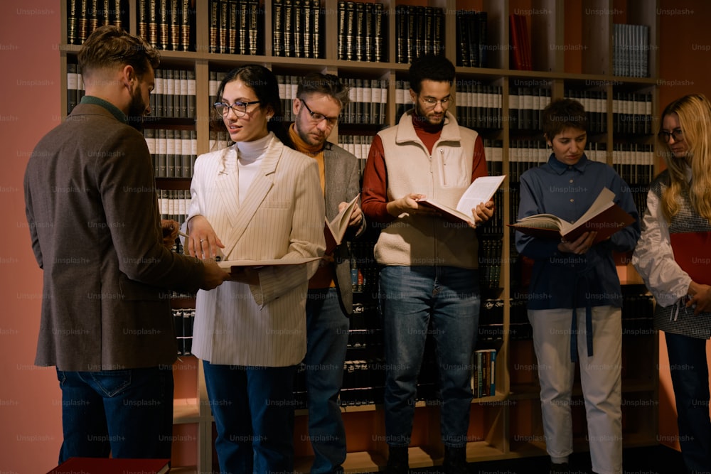 a group of people standing in front of a book shelf