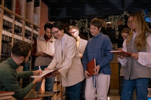 a group of people standing around each other in a library