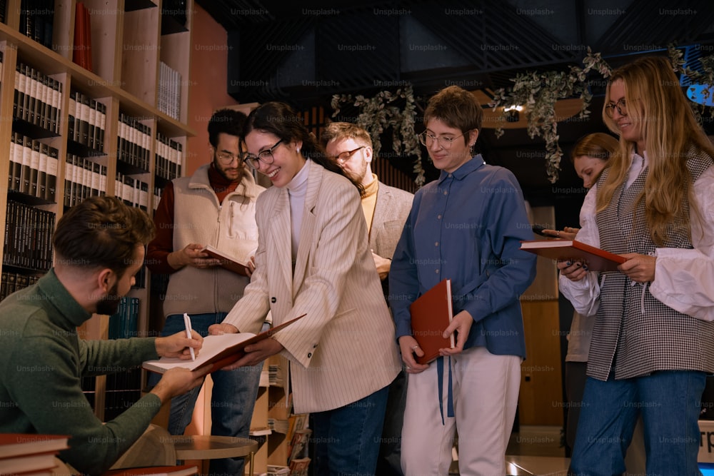 a group of people standing around each other in a library