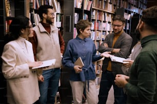 a group of people standing in front of a book shelf