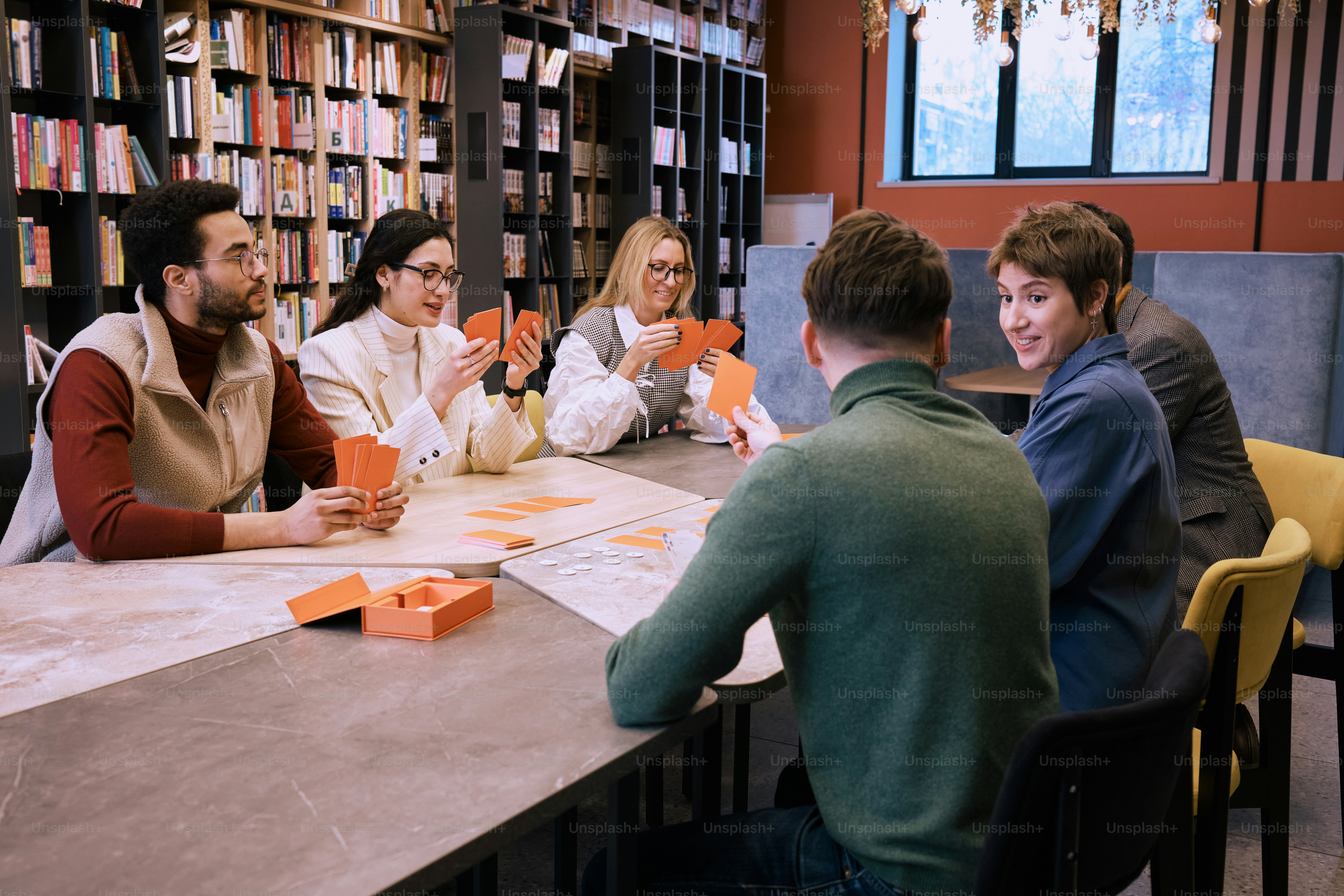 a group of people sitting around a table in a library