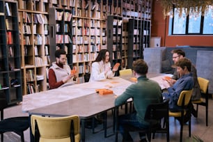 Un grupo de personas sentadas alrededor de una mesa en una biblioteca