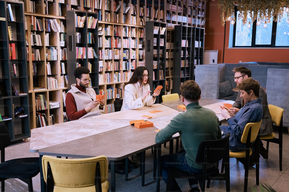 a group of people sitting around a table in a library