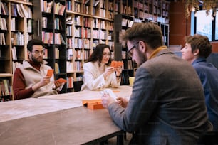 a group of people sitting at a table in a library