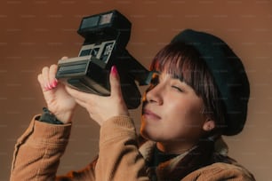 une femme tenant un appareil photo devant son visage