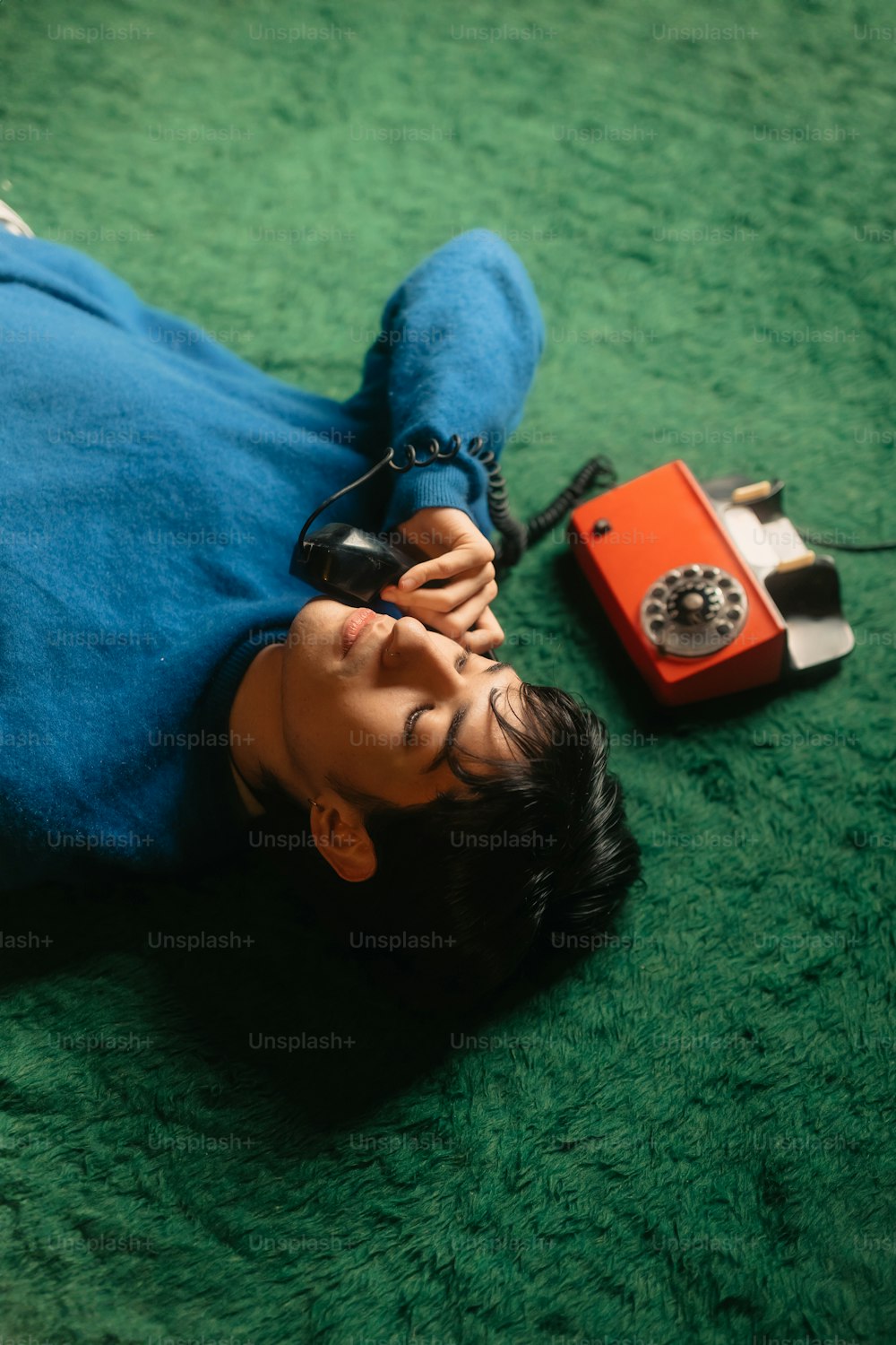 une personne allongée sur le sol avec un téléphone cellulaire