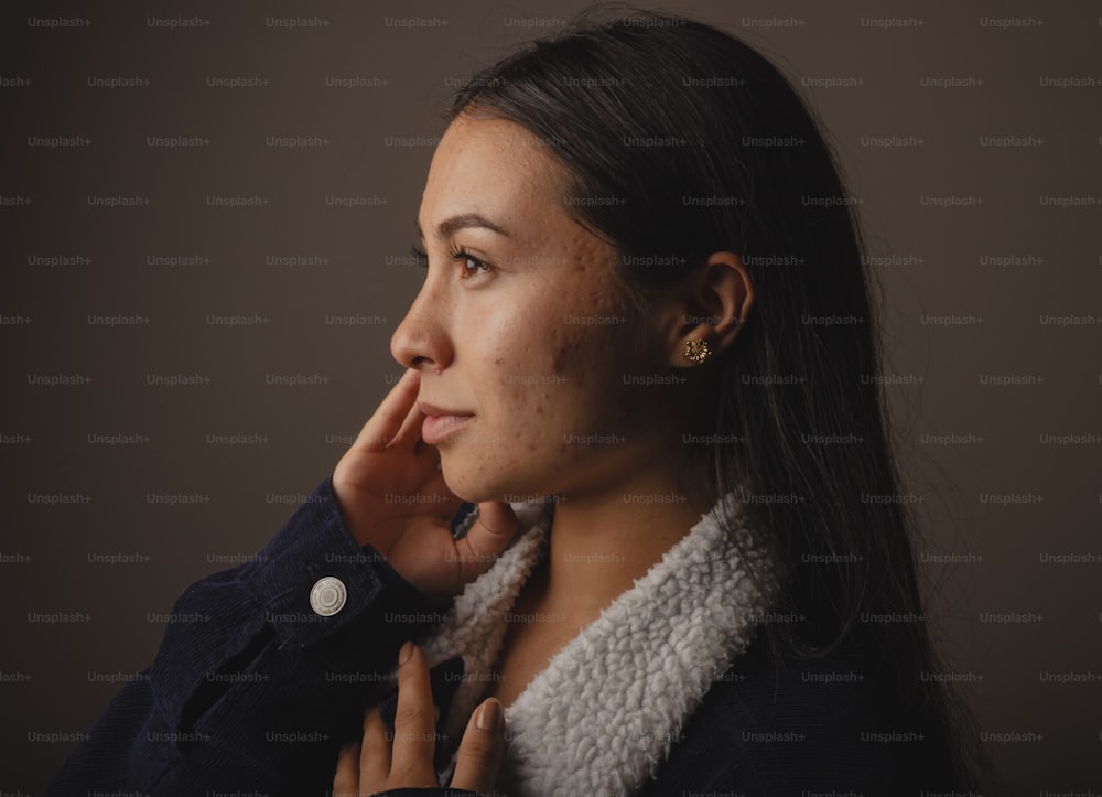 Une femme pose pour une photo avec sa main sur son menton