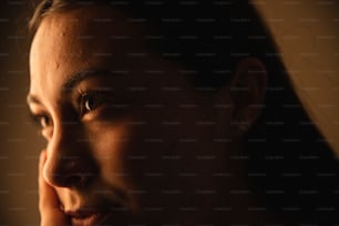 a close up of a woman's face with a dark background