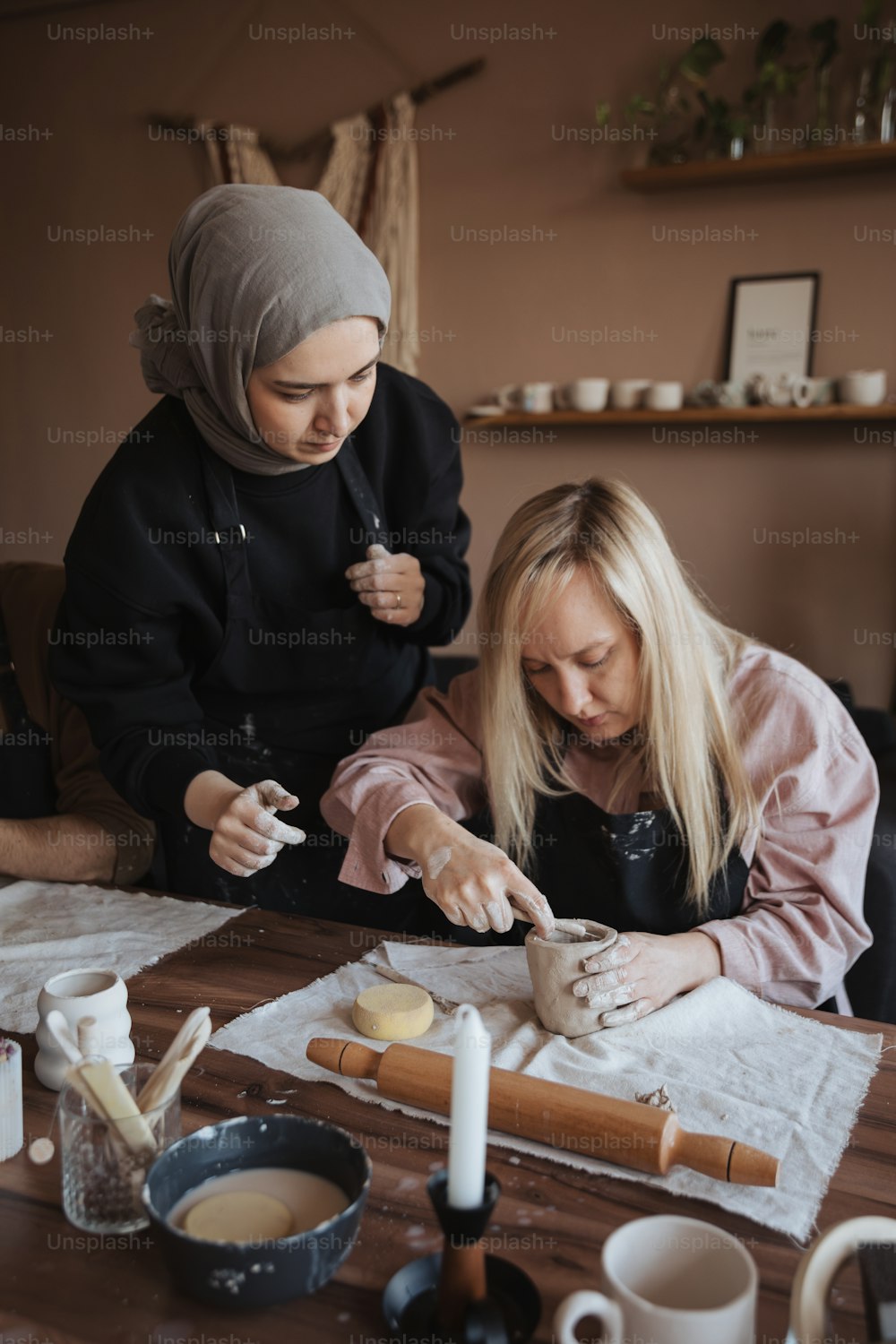 two women sitting at a table making cookies