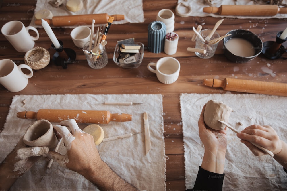 Una persona está trabajando en cerámica sobre una mesa
