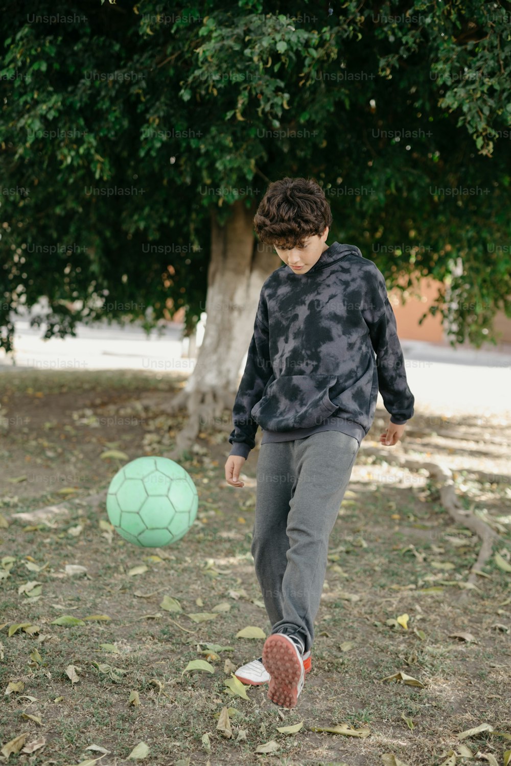 un niño pateando una pelota de fútbol en un campo