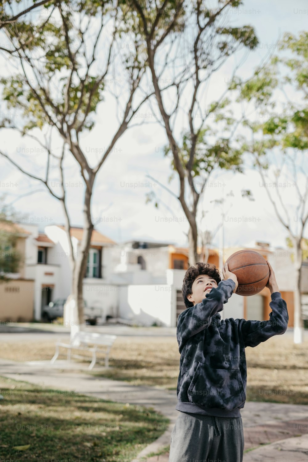 ein kleiner Junge, der einen Basketball vor sein Gesicht hält