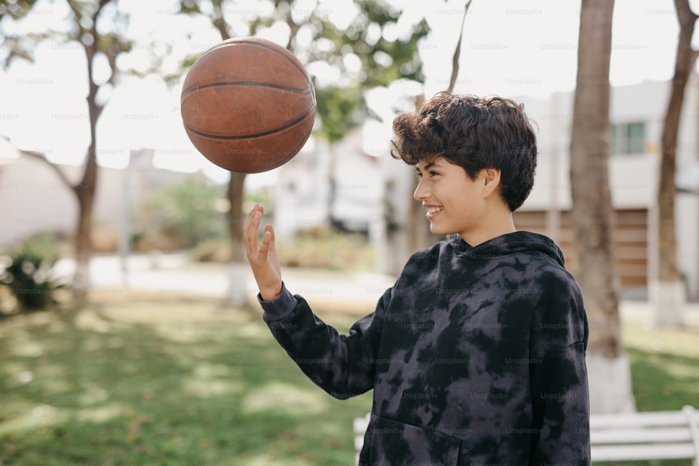 Um garoto está girando uma bola de basquete em seu dedo