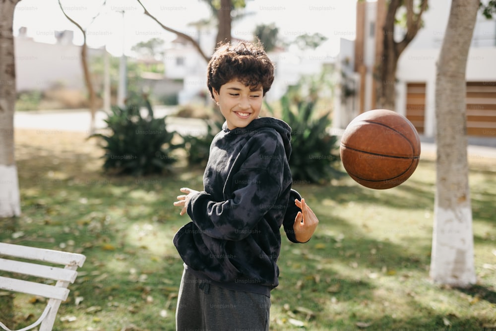 한 어린 소년이 농구공을 가지고 놀고 있다