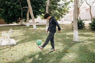 a young man kicking a soccer ball in a yard