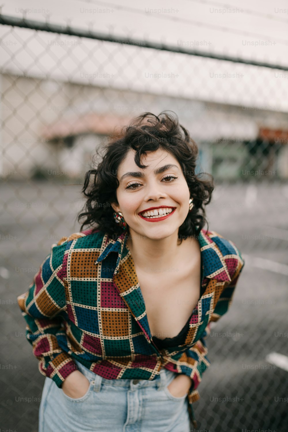 a woman standing in front of a chain link fence