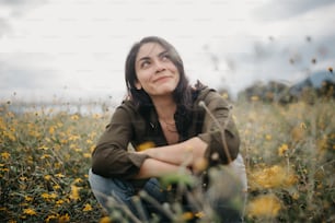 eine Frau sitzt in einem Feld mit gelben Blumen