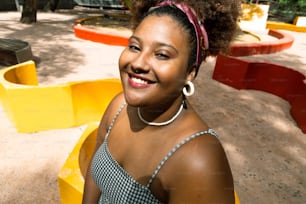 Eine Frau mit Afro lächelt in die Kamera