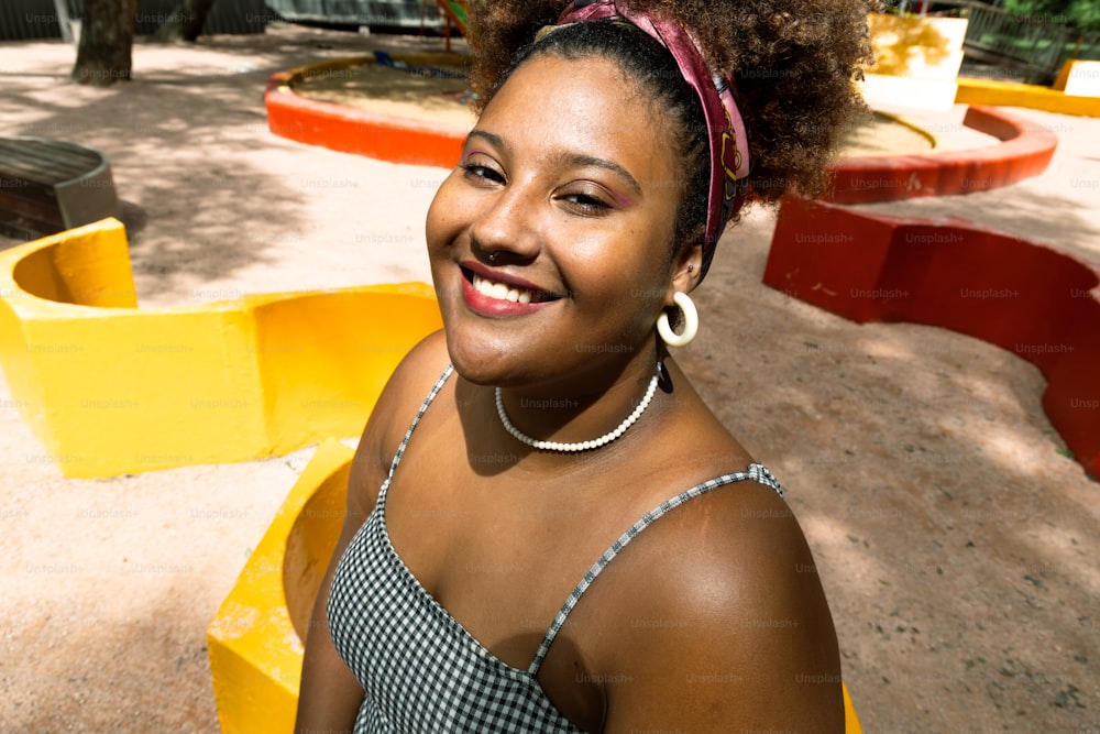 Una donna con un afro sorride per la macchina fotografica