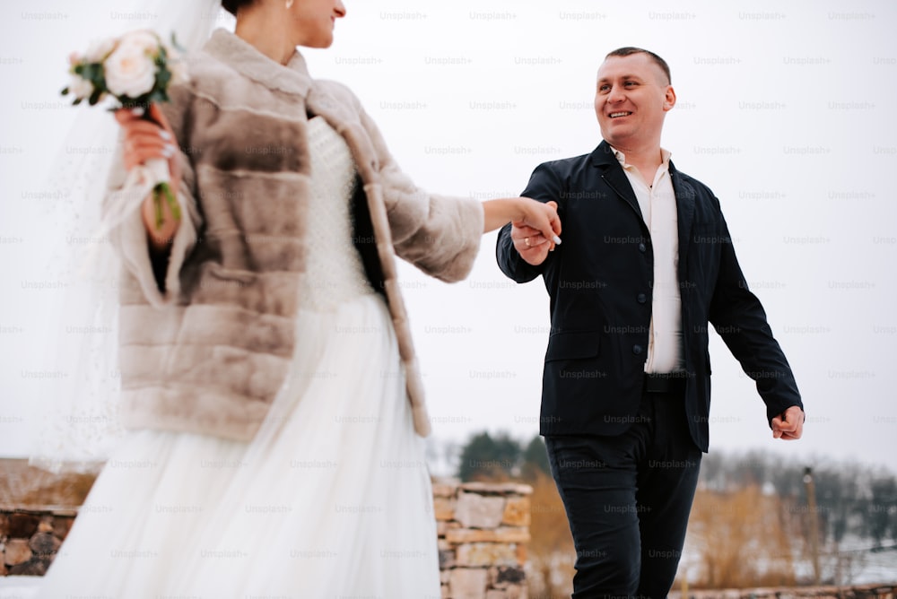 a bride and groom holding hands and walking