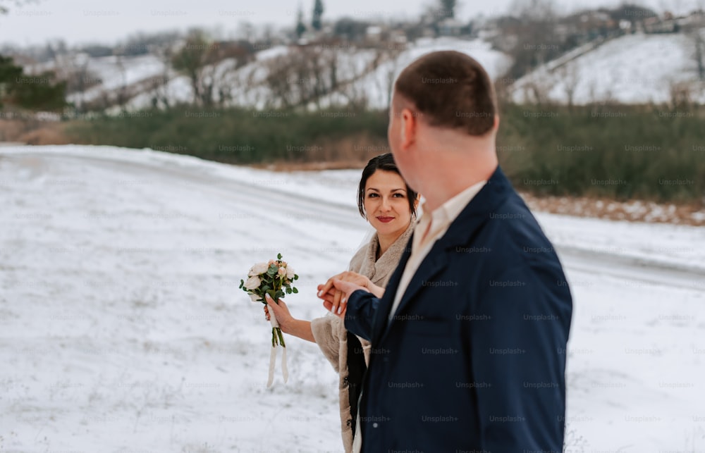 a woman holding a bouquet of flowers next to a man