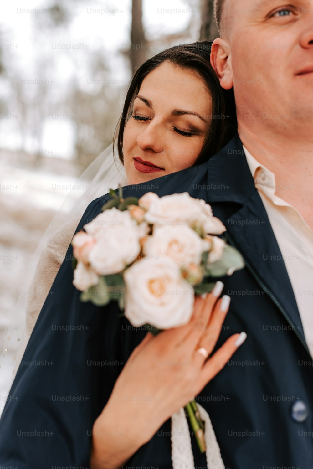 a bride and groom embracing each other in the snow