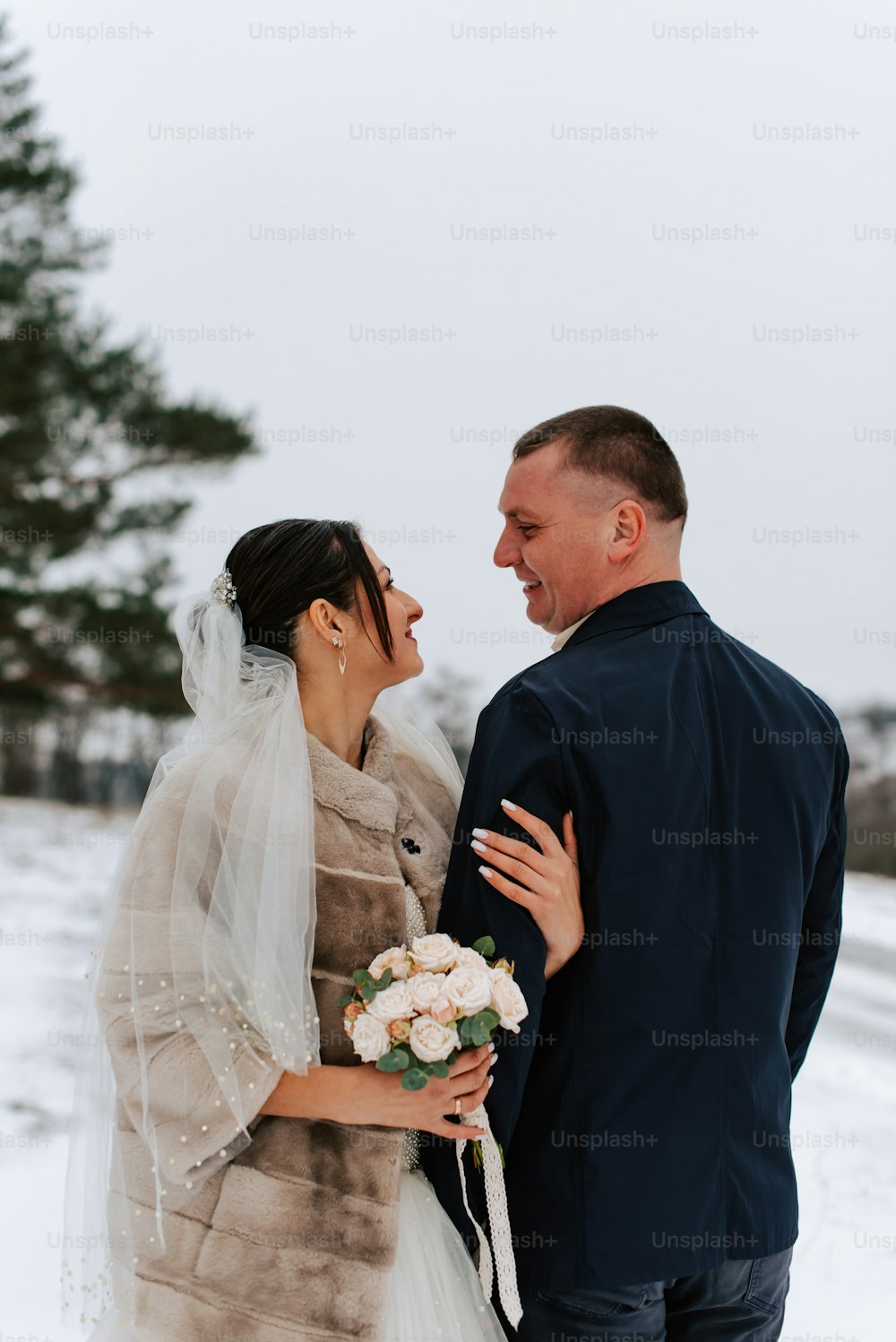 Braut und Bräutigam stehen im Schnee