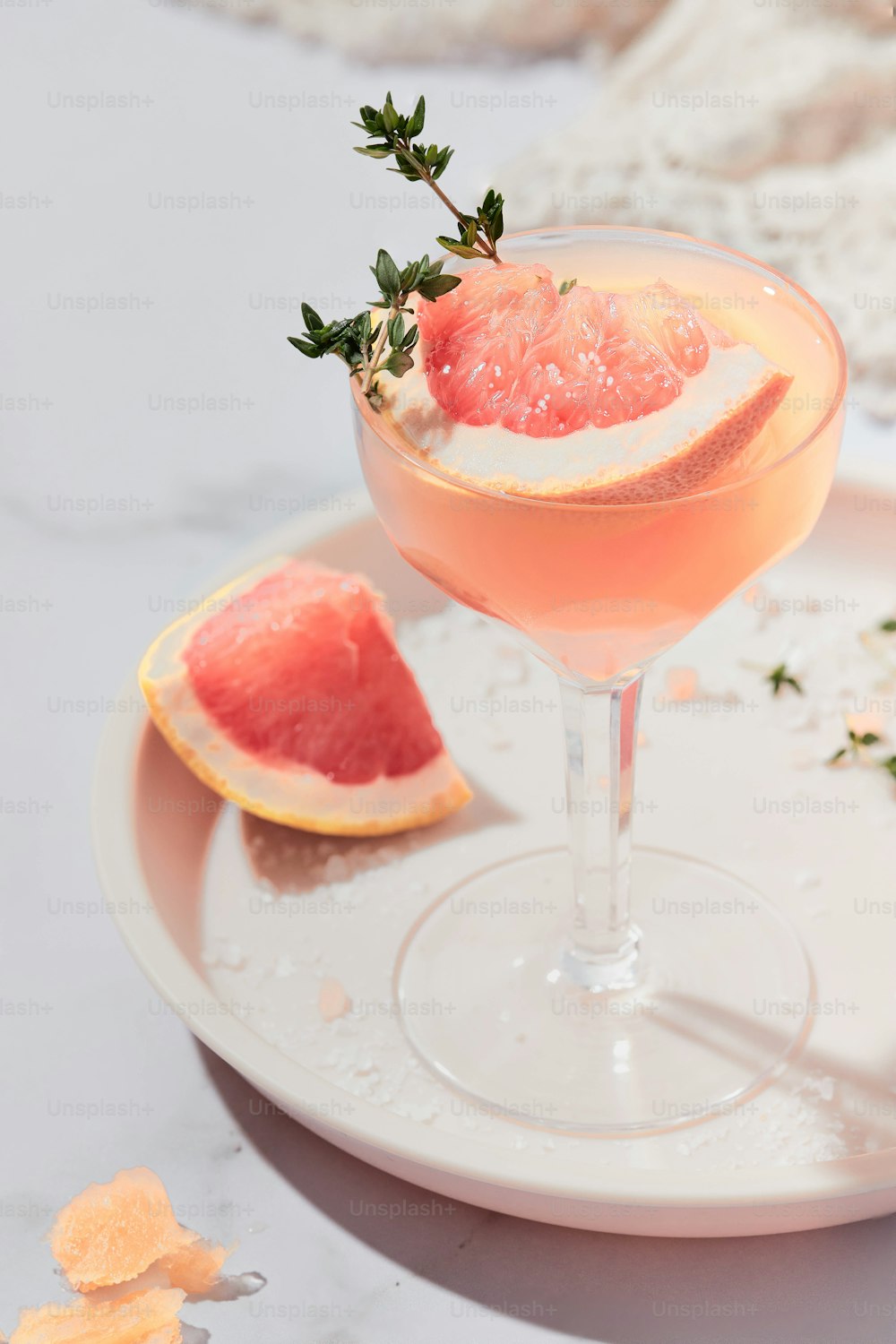 a grapefruit cocktail garnished with a sprig of rosemary