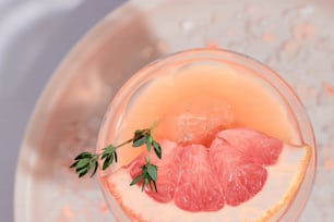 a grapefruit drink with a sprig of green garnish