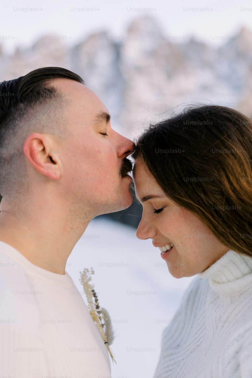 Un hombre y una mujer se besan en la nieve