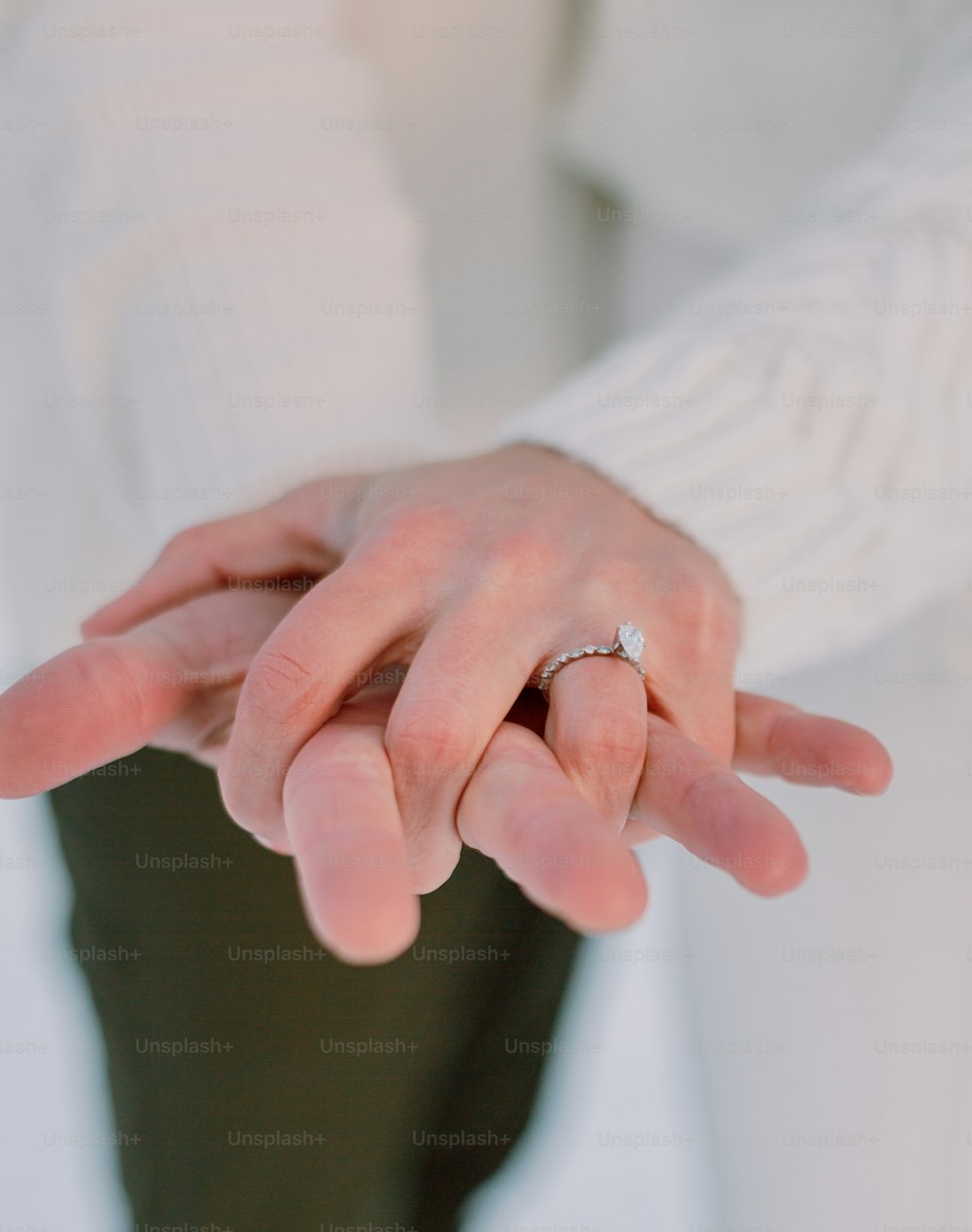 a close up of a person holding a wedding ring